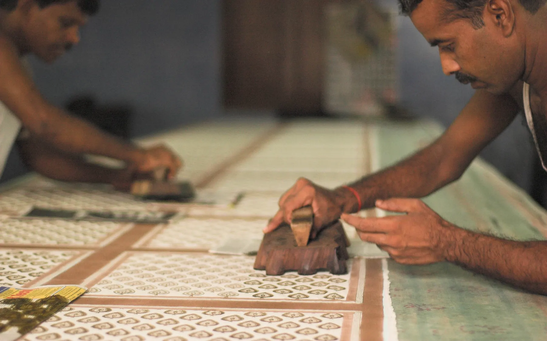 Two block-printers working a length of cloth at Bagru
